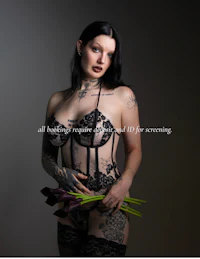 a woman with tattoos holding a bouquet of flowers