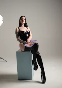 a woman in latex stockings sitting on a box